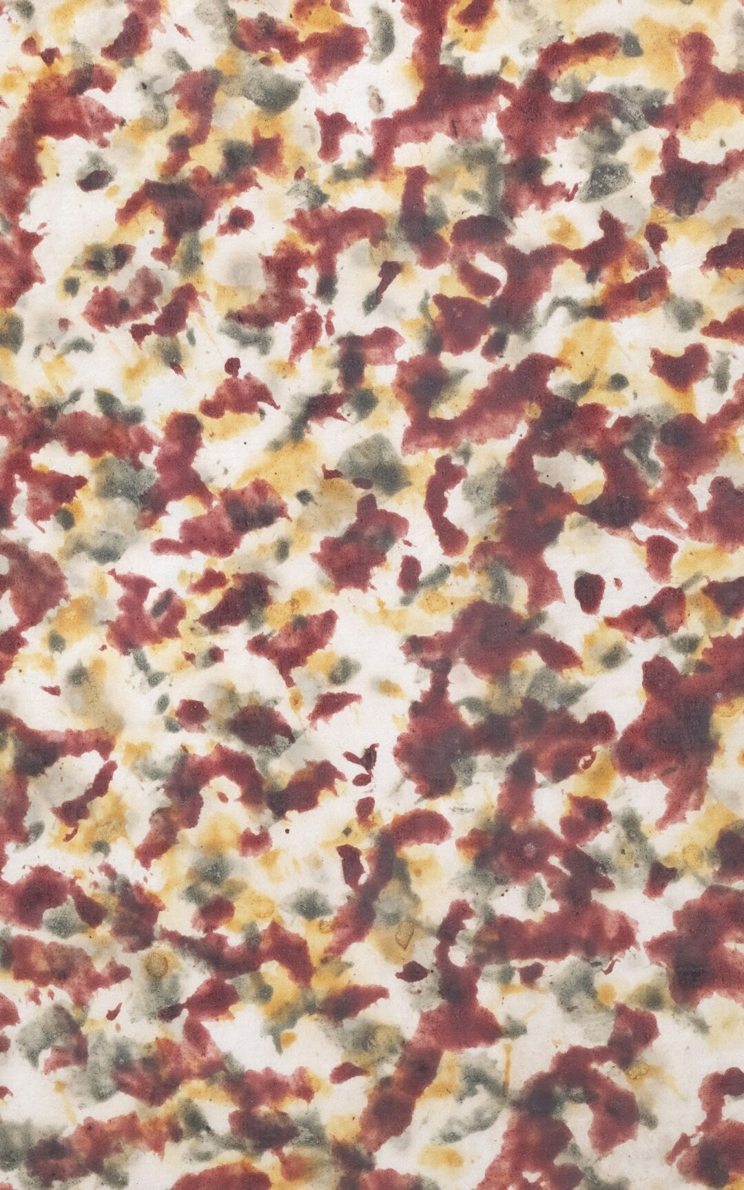 Patrón textil abstracto en tonos burdeos y dorados fotografiado de cerca