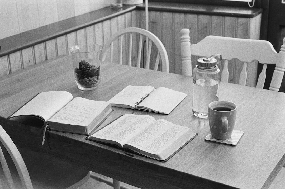 Pila de revistas editoriales sobre una mesa de madera con luz cálida